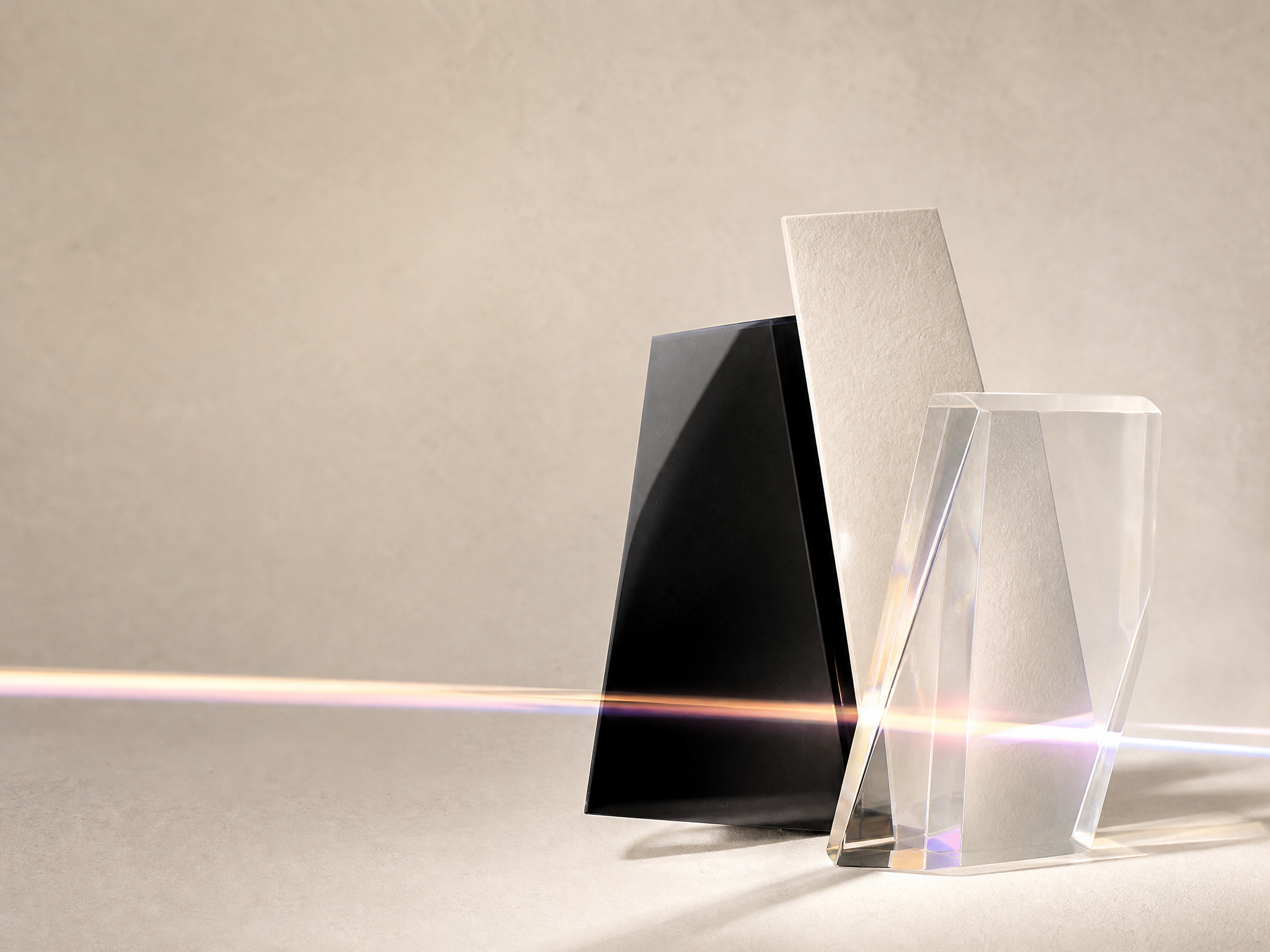 Intersecting stone, paper, and crystal forms with a prismatic band of light